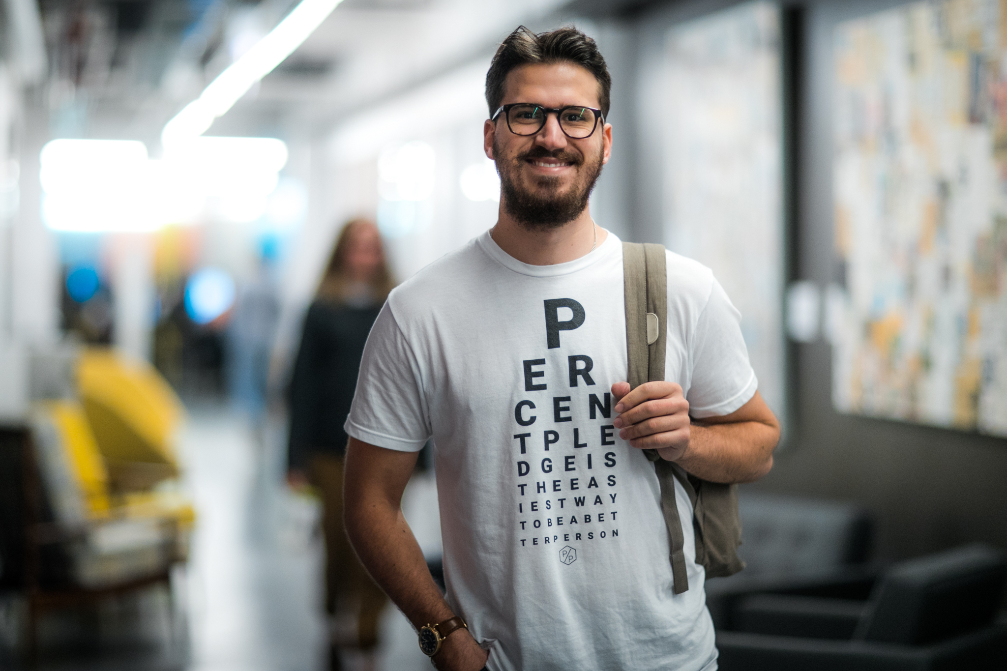 Percent Pledge founder Joel Pollick smiles at camera while wearing Percent Pledge logo t-shirt